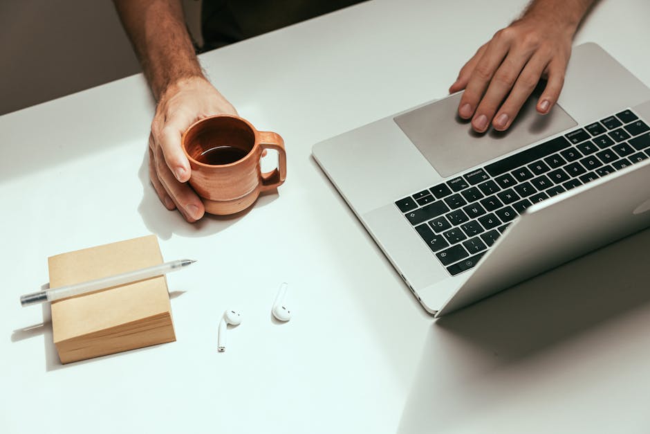Graduate at a desk with laptop and coffee