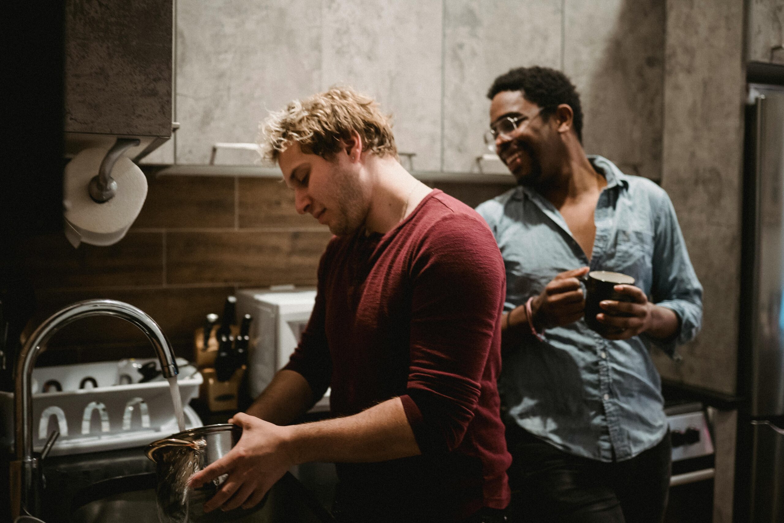 Young flatmates socialising in their shared house kitchen