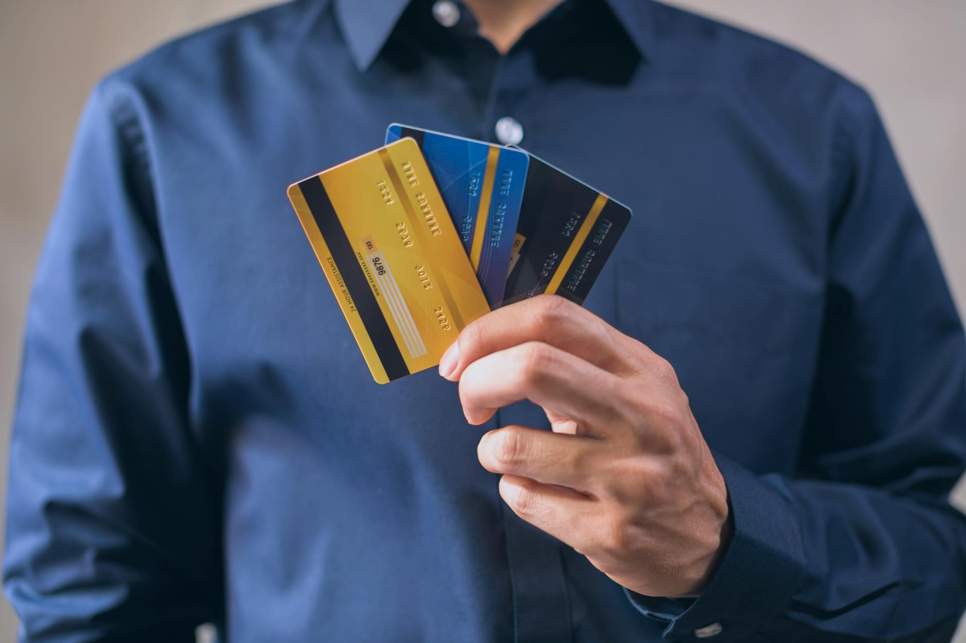Graduate holding debit cards while managing their finances after university