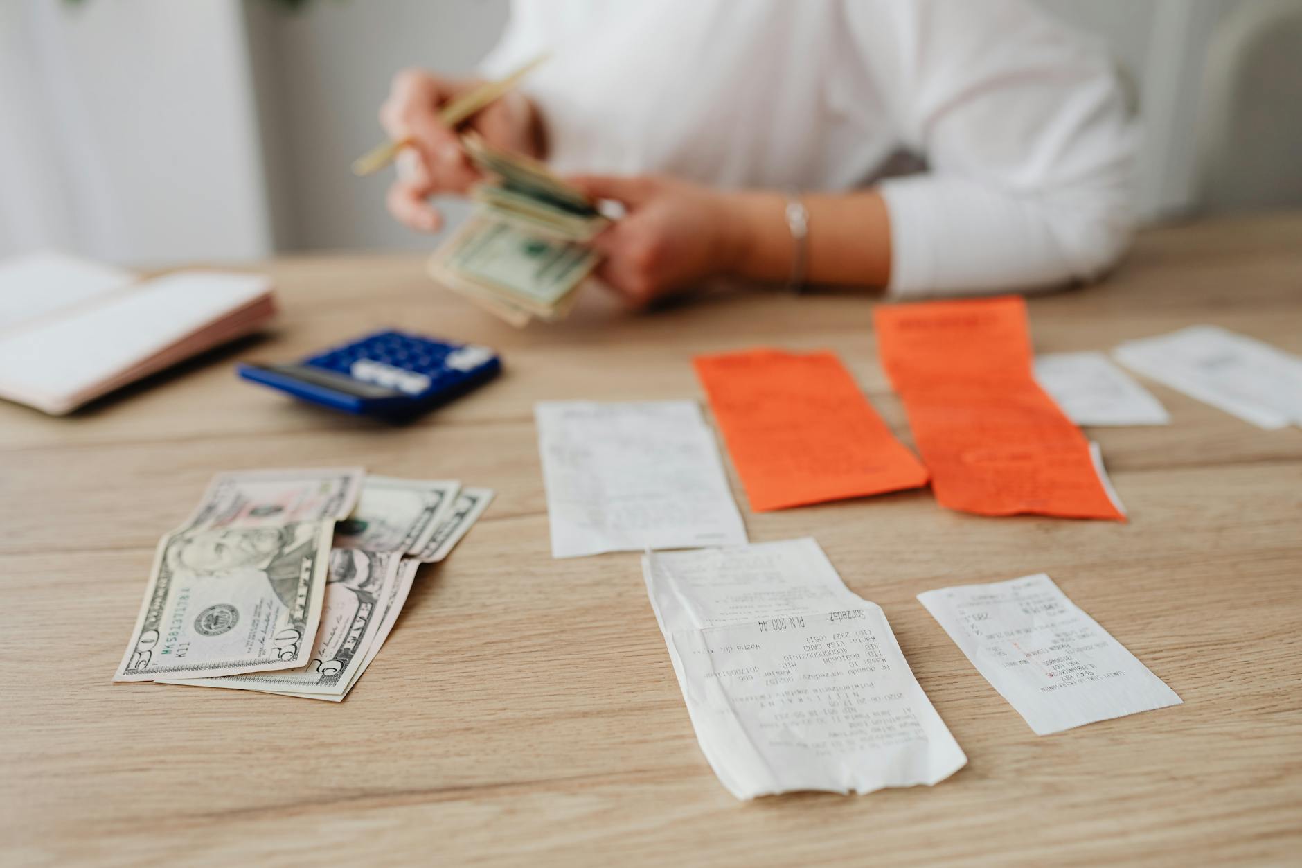 Student planning their budget with a calculator and cash for living costs at university