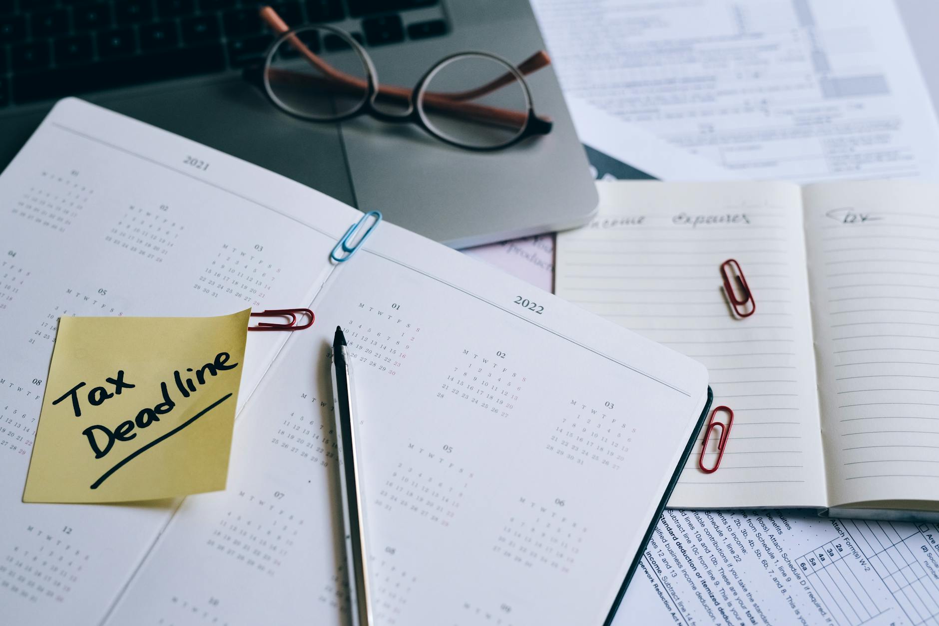 Desk planner with a key deadline highlighted and a sticky note reminder