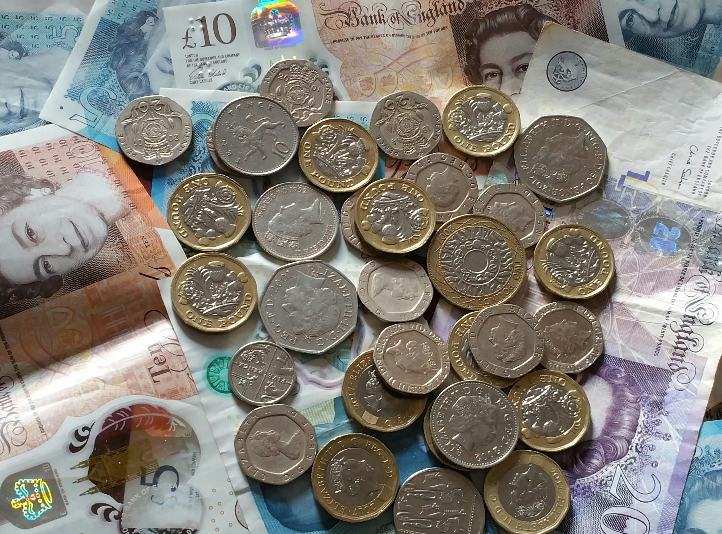British five-pound notes in a wallet for everyday cost cutting