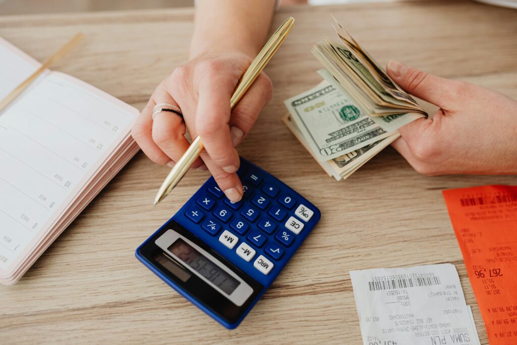 Calculator notebook and pen on a desk used for working out a budget