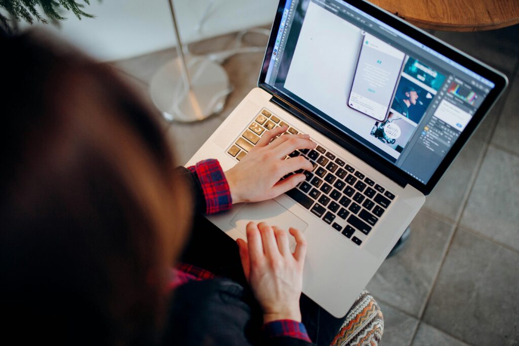 Freelance graphic designer working on a laptop with design software