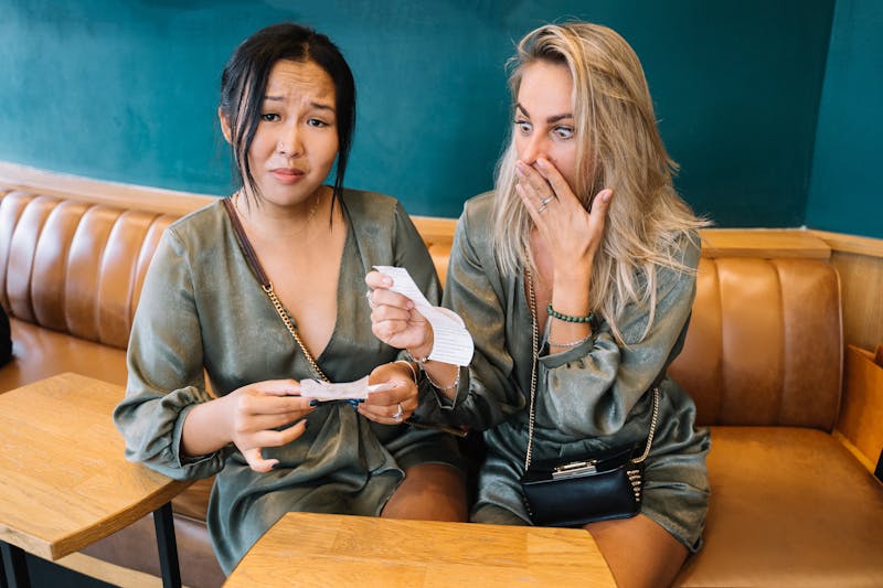 Two friends looking at a restaurant bill to split