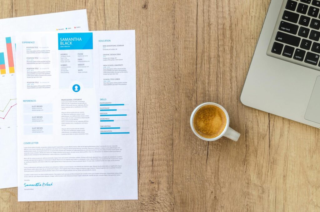 CV laid out on a desk next to a laptop and coffee mug, ready for editing