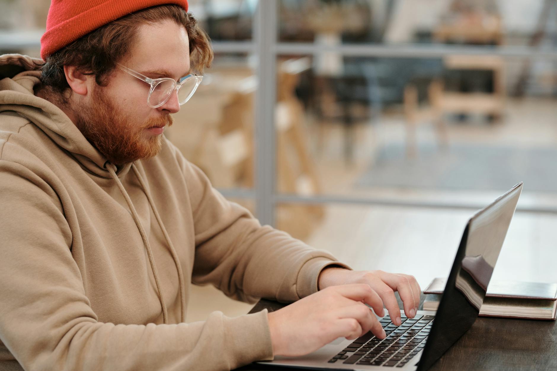 Young person job hunting on a laptop in a cafe