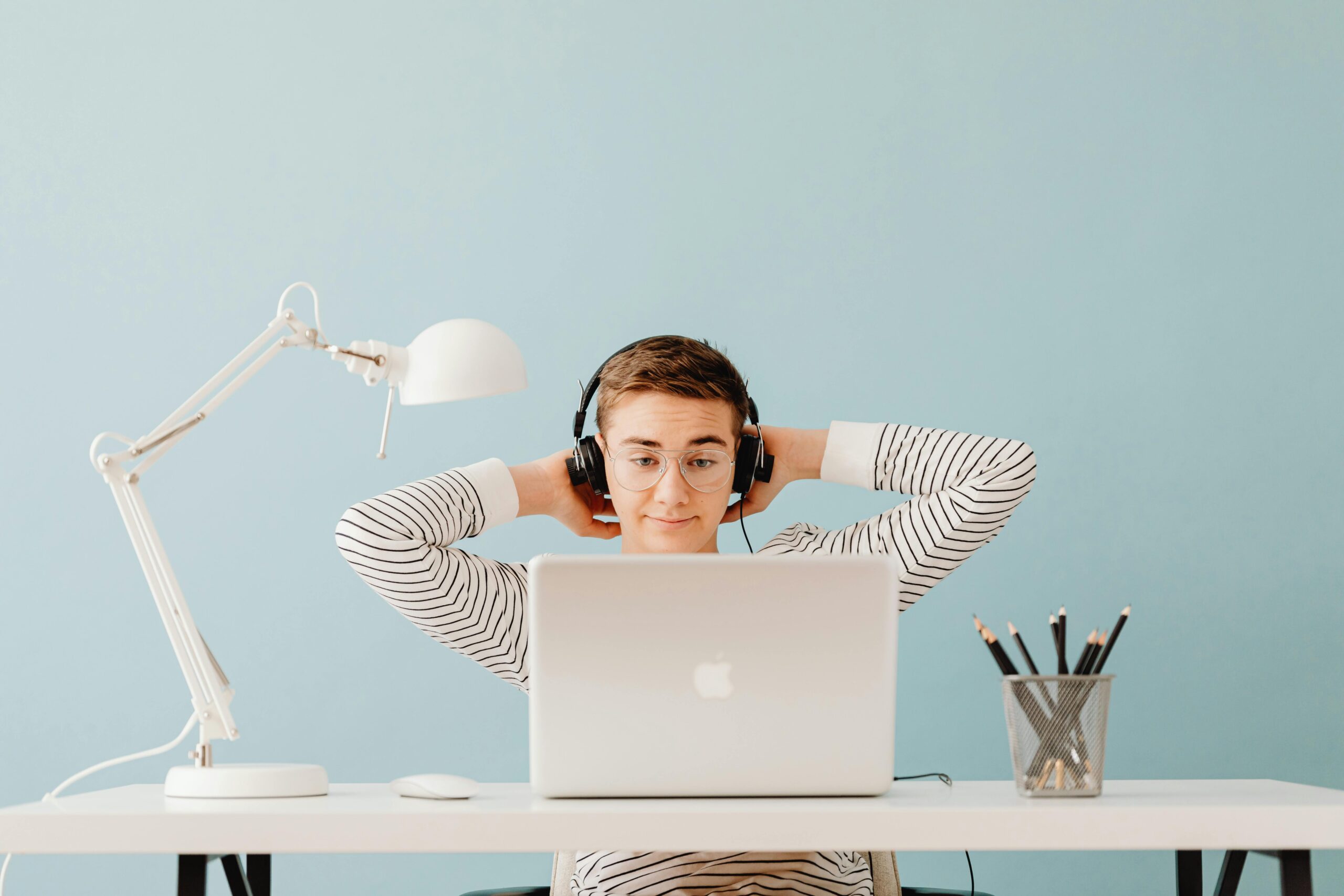 Headphones in a hard-shell case next to a laptop