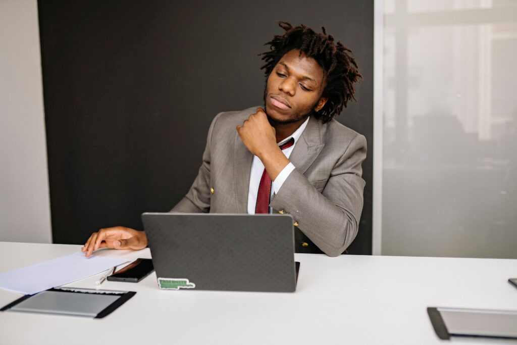Focused businessman working at desk with laptop and documents in modern office