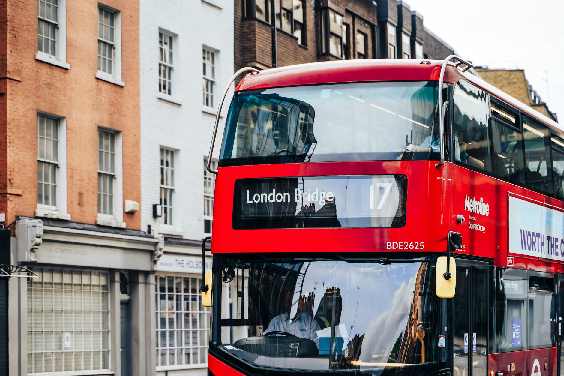 Red London double-decker bus crossing London Bridge on route 17