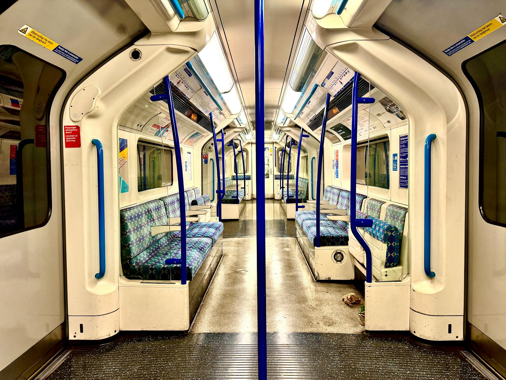 Empty London Underground carriage interior with red and blue moquette seats