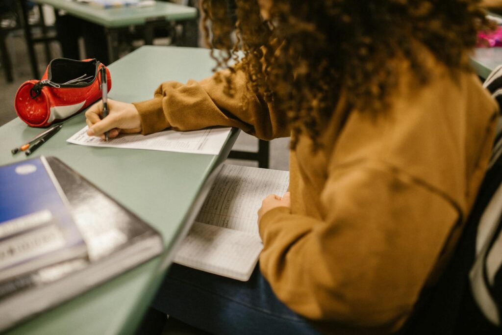student writing exam paper desk