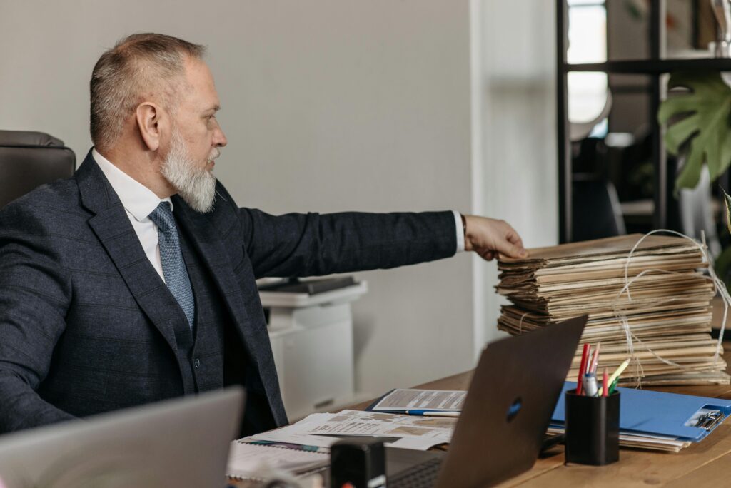 Mature student looking at paperwork at a desk with concerned expression
