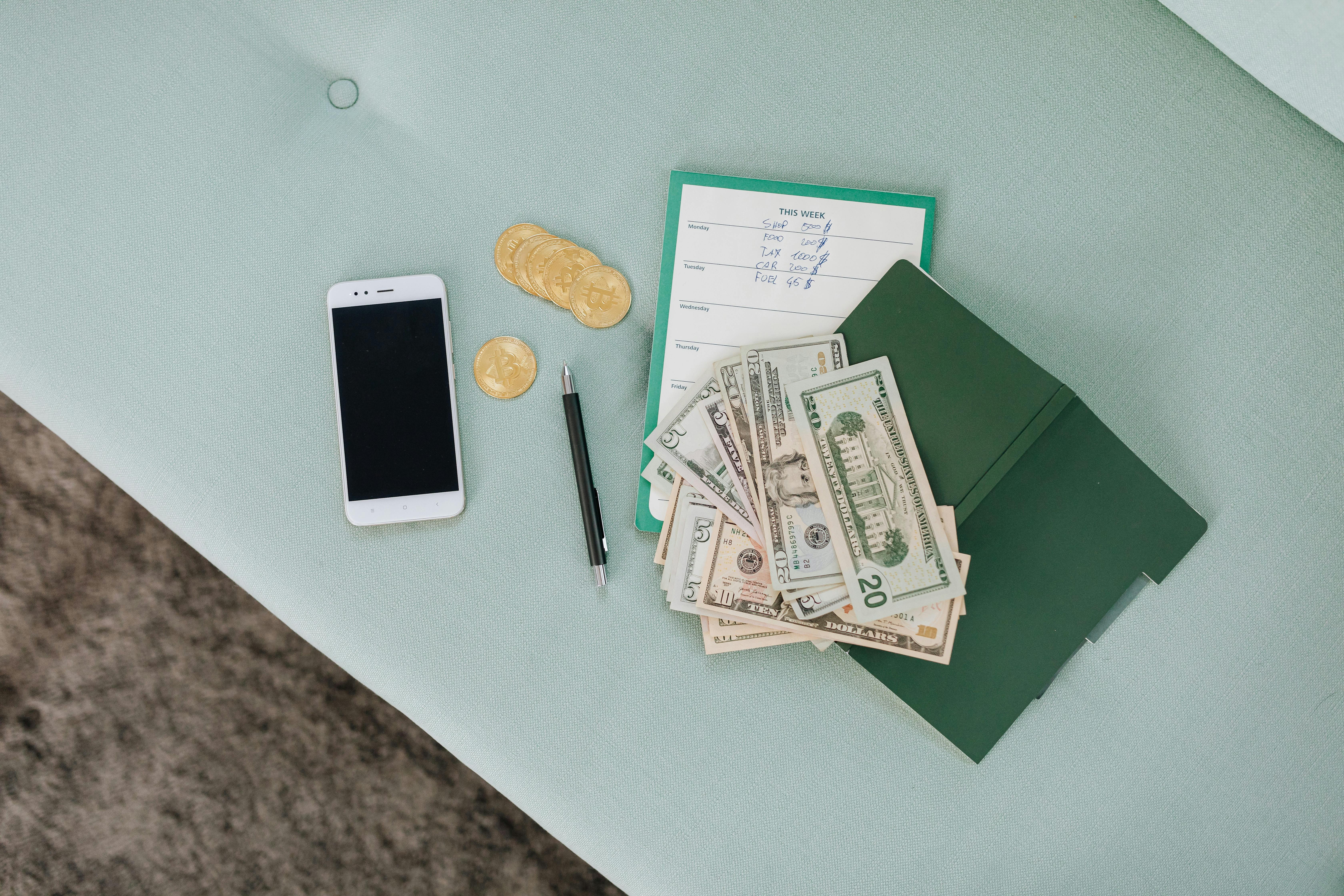 Budget spreadsheet setup with notebook, calculator and pound coins on a desk