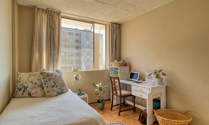Bright student room with furniture and laptop