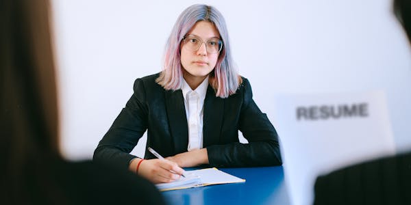 Young woman writing notes at a job interview