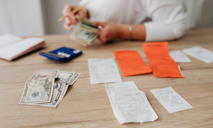 Person budgeting with calculator and cash