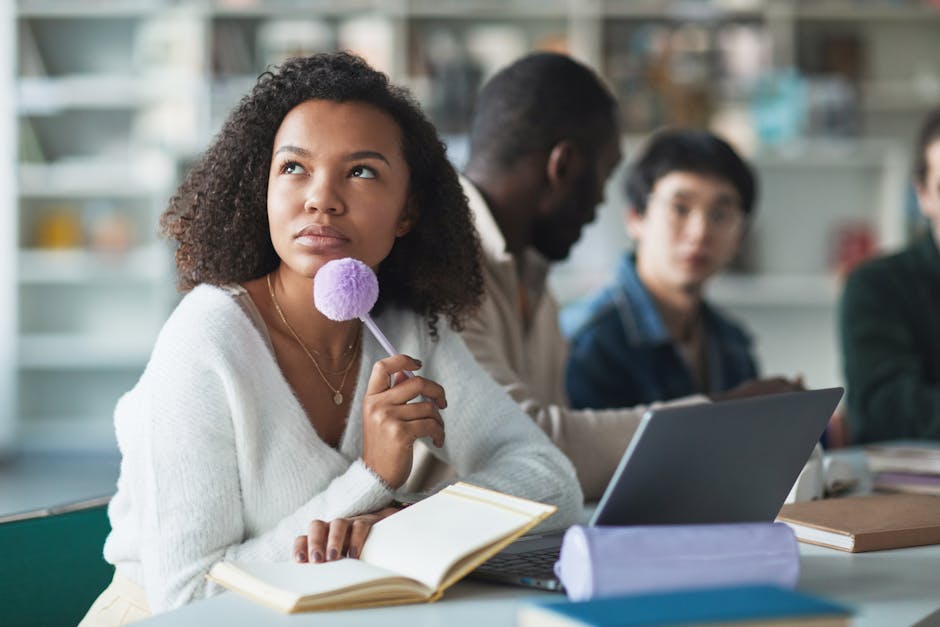 Student pondering next steps with a pen in hand