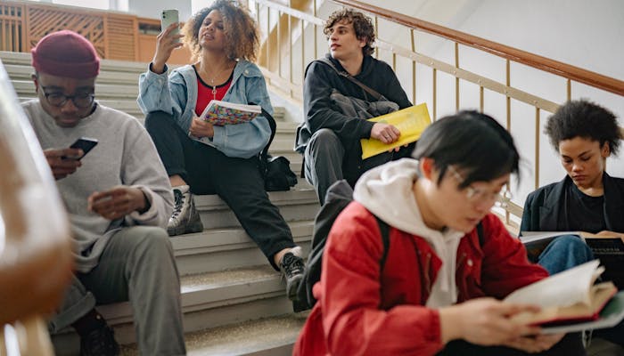 Students sitting on university steps with books