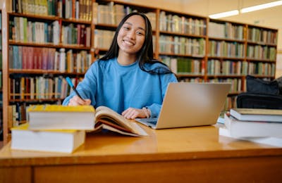 Student smiling while studying in library