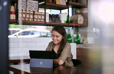 Young woman using laptop in a cafe