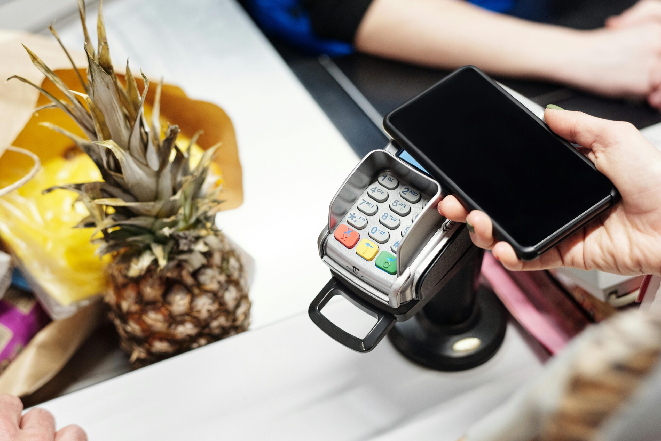 Student scanning a supermarket loyalty app on a smartphone at checkout