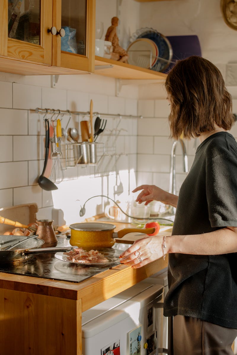 Student cooking breakfast in a sunny kitchen