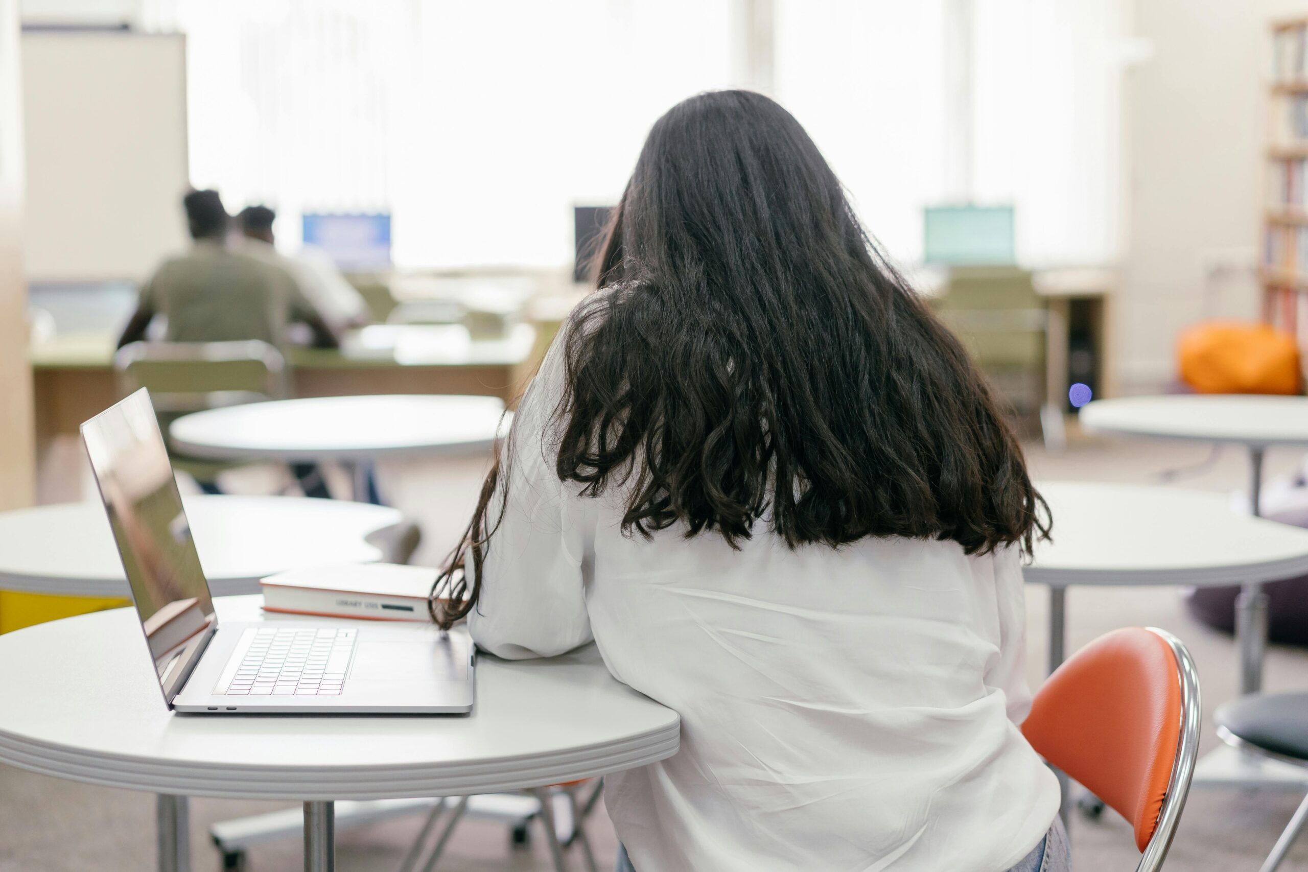 Student studying with a laptop at a university library table