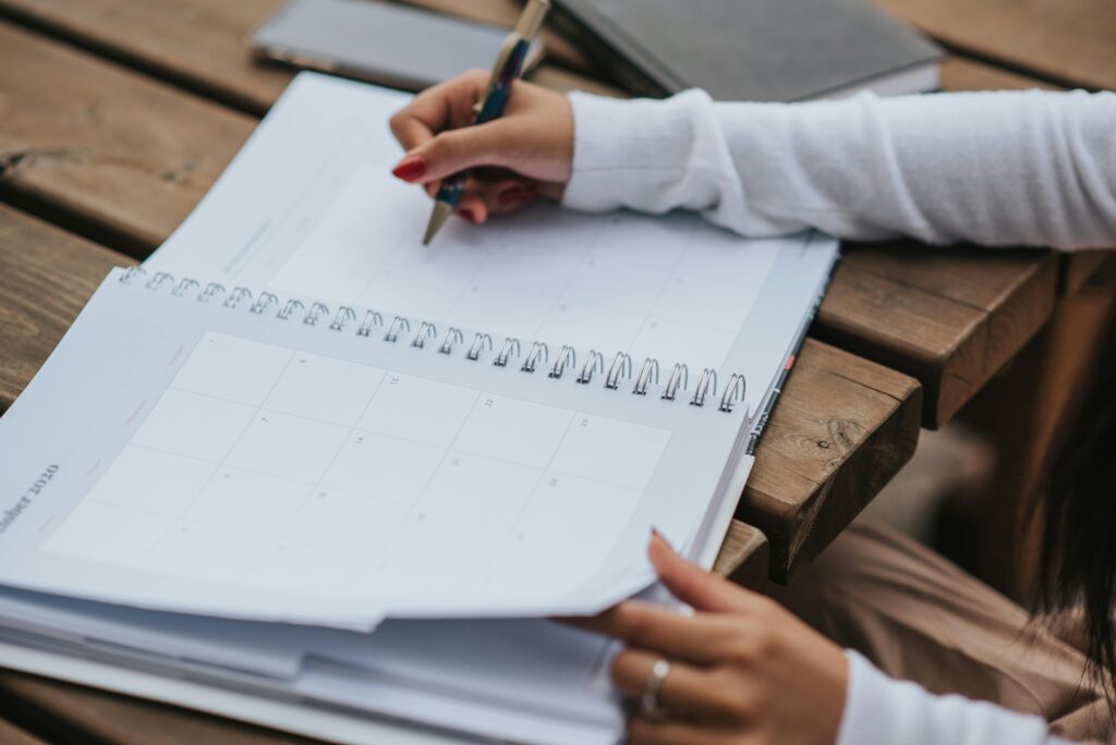 Student writing a revision timetable to revise for exams in a planner