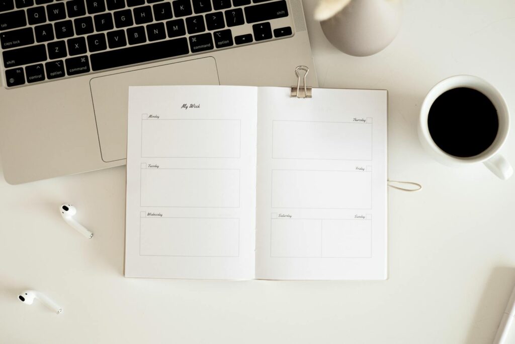 Planner, laptop and coffee on a desk ready to fill in a student budget template