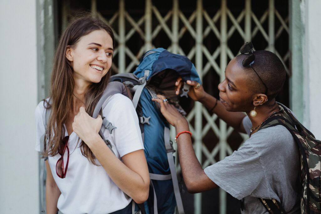 Two young women with backpacks exploring city streets, enjoying their travel and friendship.