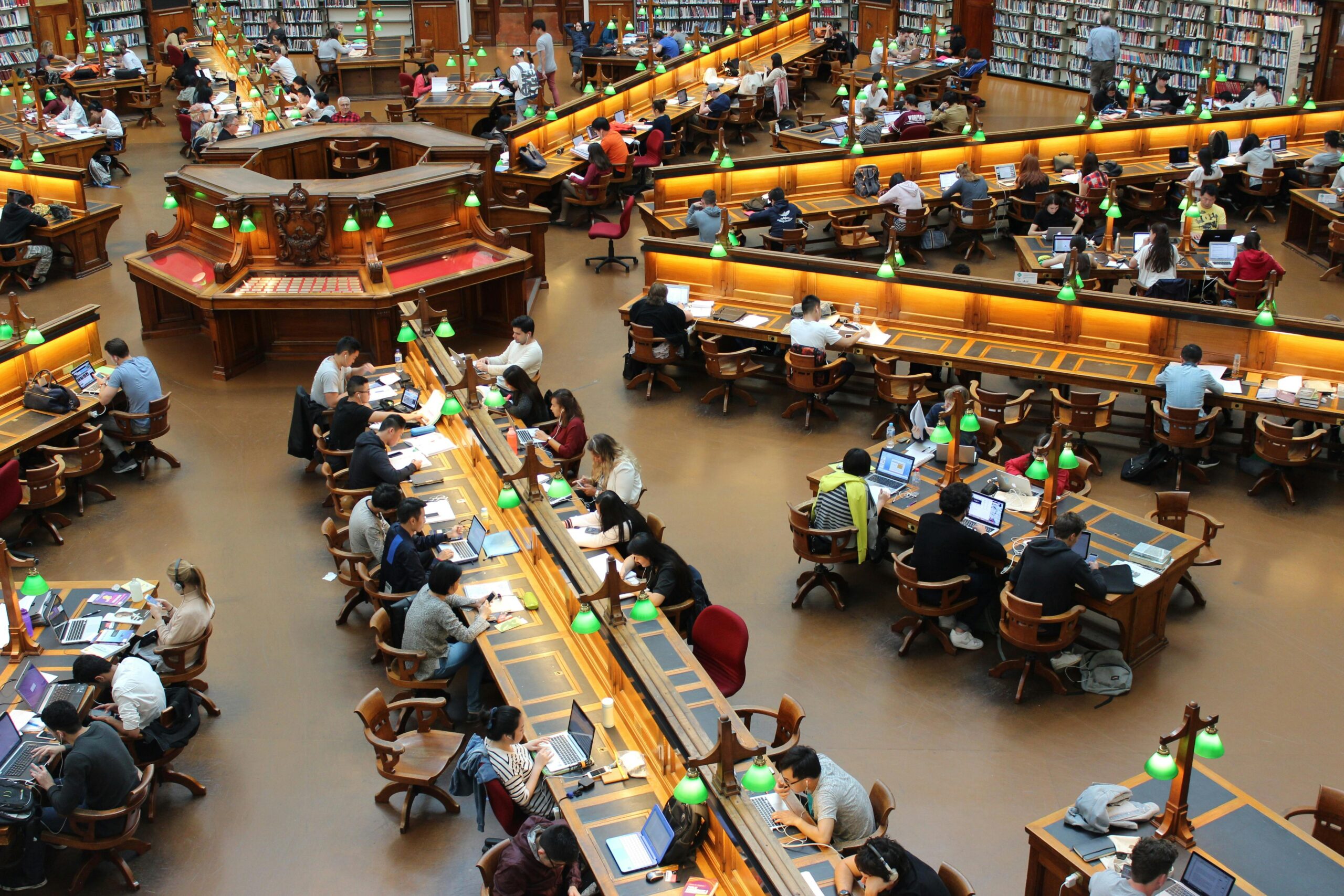 Students studying at a UK university library with books and notes
