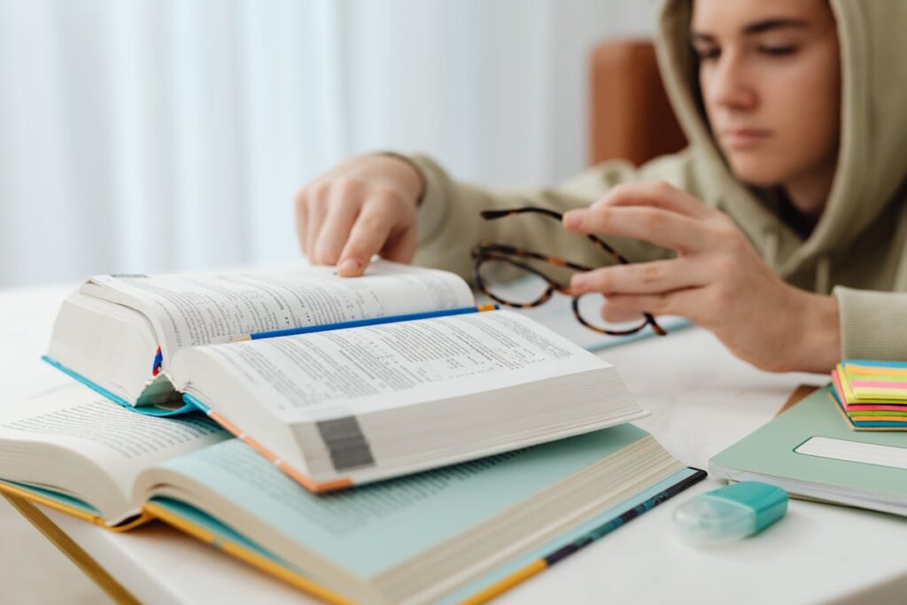 Focused student revising at desk with snacks nearby