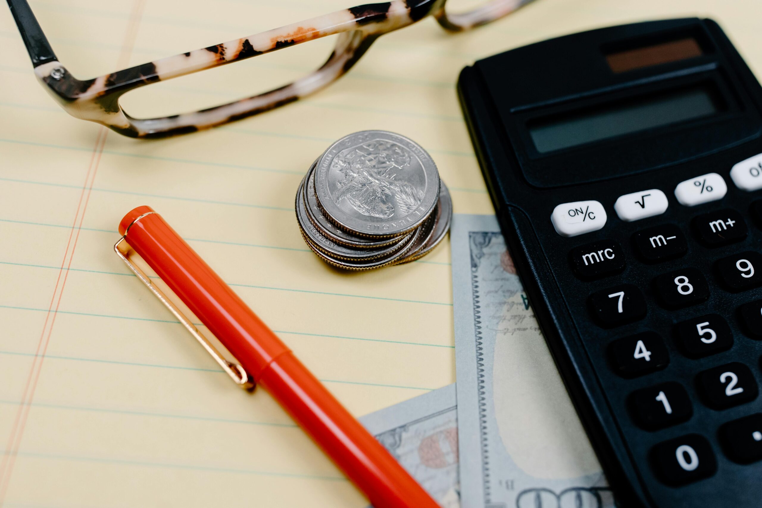 Calculator and UK pound coins on a desk, illustrating salary deductions
