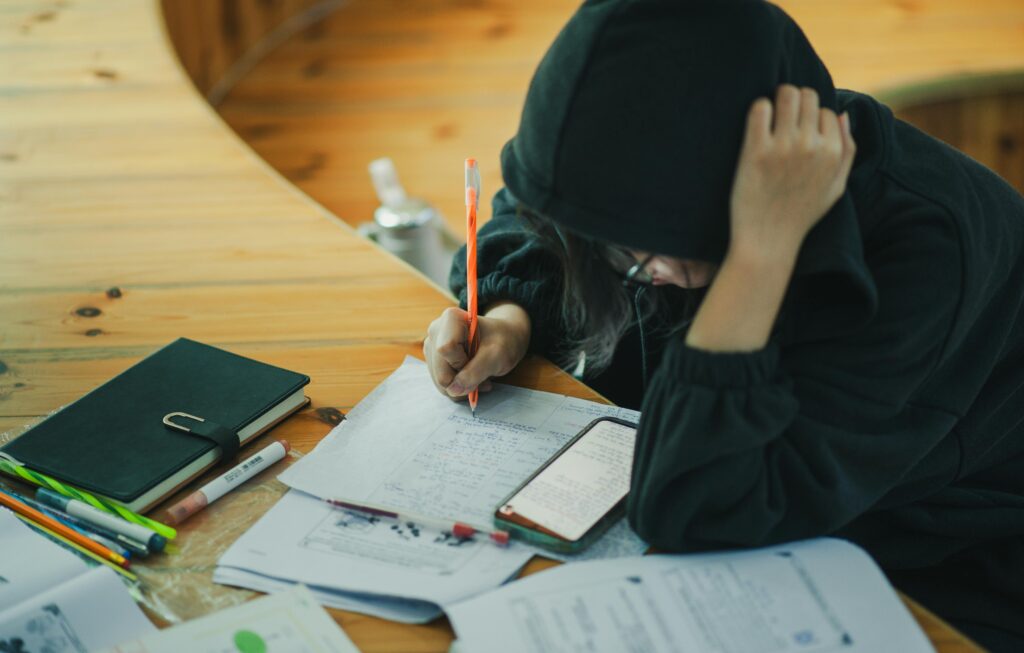 A student at a desk writing notes while planning to reapply with a stronger application