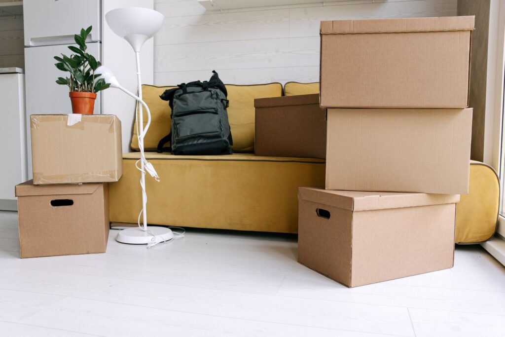 Cardboard moving boxes and a rucksack in a room on moving-in day