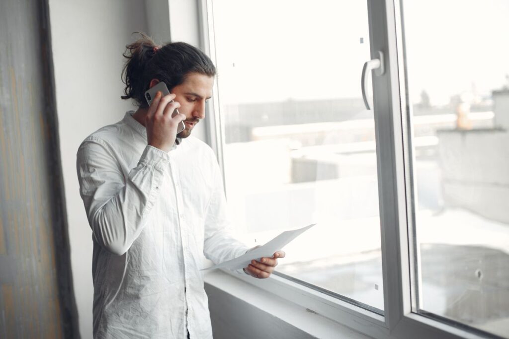 Student on the phone to a university admissions team holding their A-level results