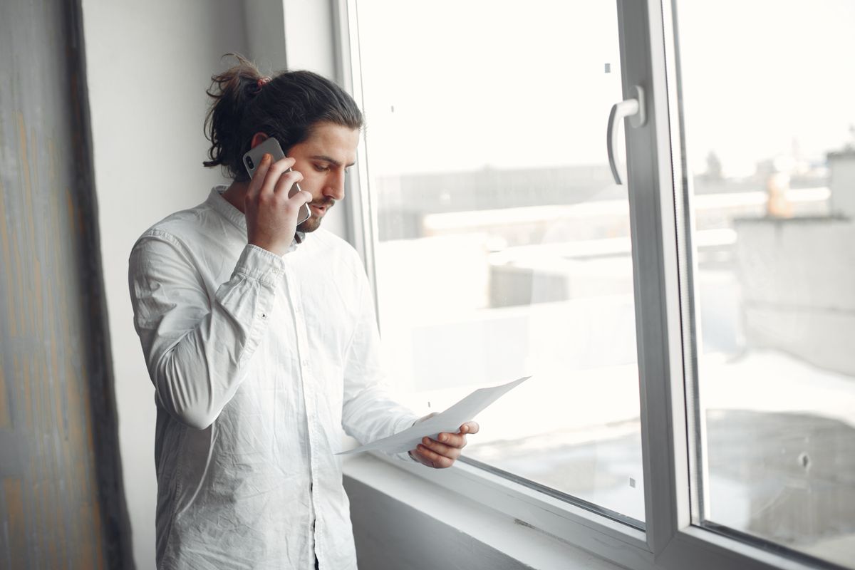 Student on the phone to a university admissions team holding their A-level results