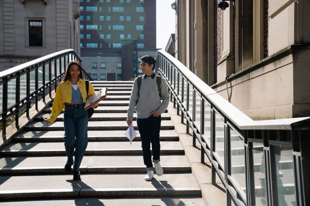 Two students walking down university campus steps after A-level results day