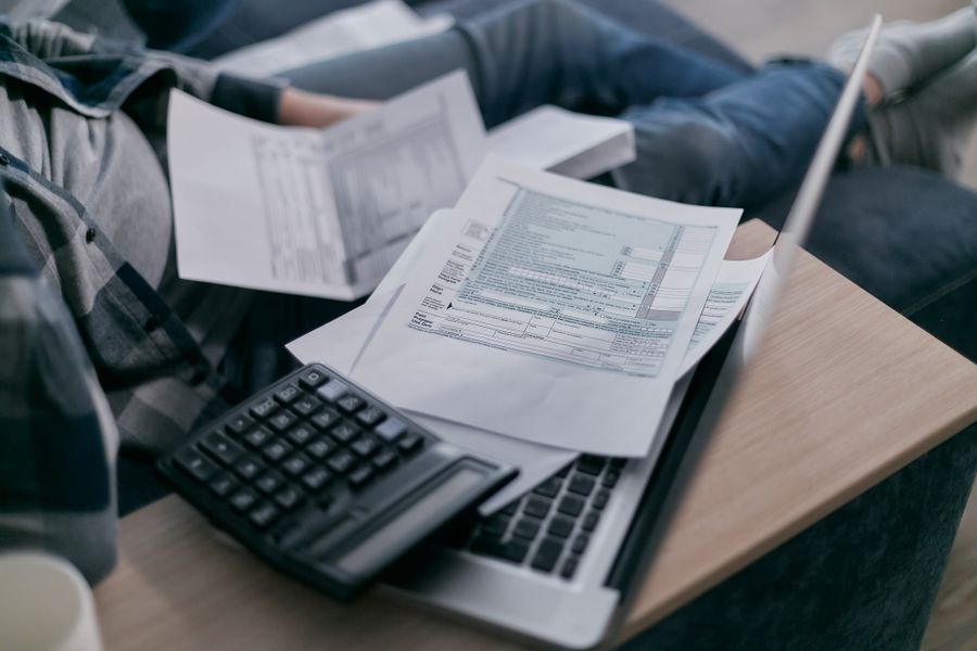 Student working out rent and bills with a calculator and laptop