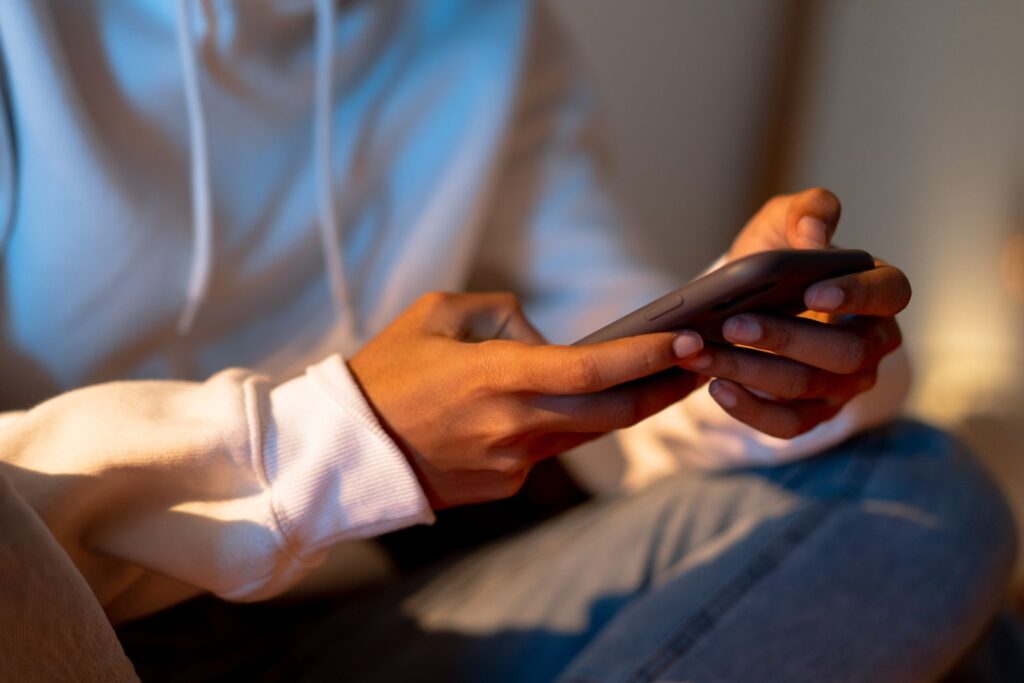 A student checking their phone for messages about the data breach