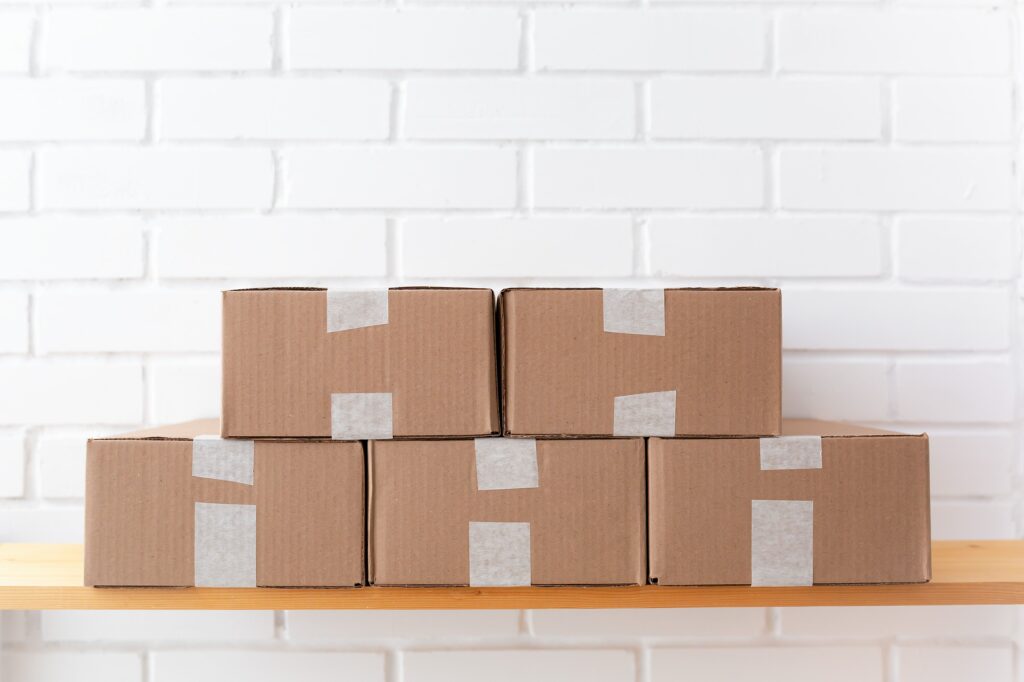 A neat stack of cardboard delivery parcels against a white wall