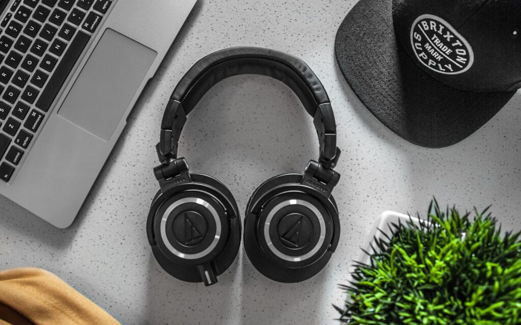 A laptop and over-ear headphones on a desk