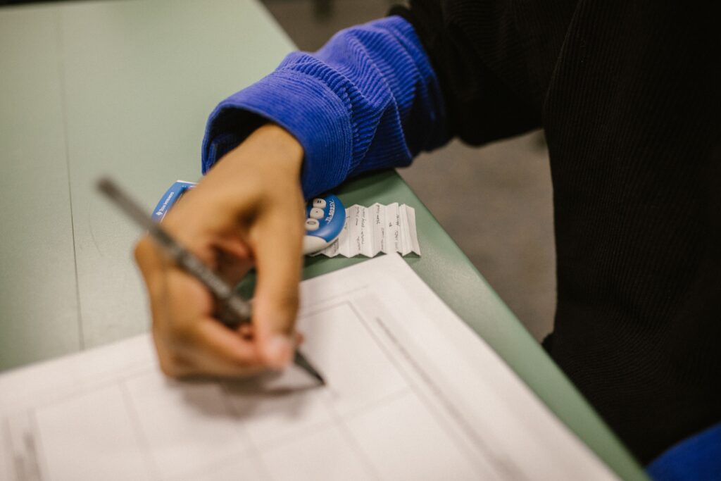 A student looking over their exam results, weighing whether a missed grade is worth a remark