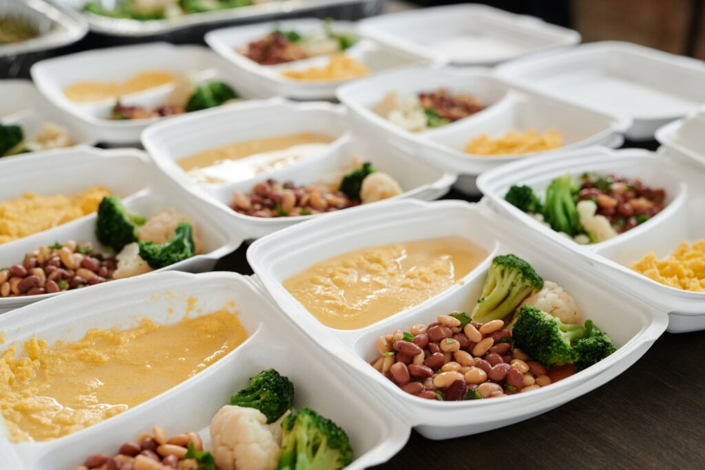 Batch-cooked budget meals with beans, broccoli and polenta portioned into containers