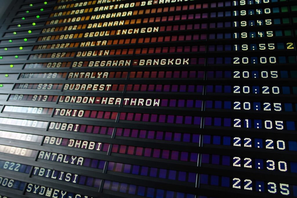Airport departure board listing flights including one to London Heathrow