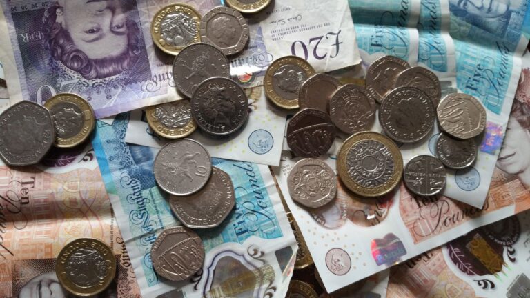 Close-up of British coins and banknotes, showing different denominations for financial concepts.