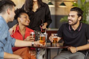 Friends enjoying drinks and socializing at a cozy bar setting.