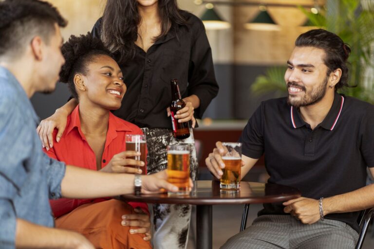 Friends enjoying drinks and socializing at a cozy bar setting.
