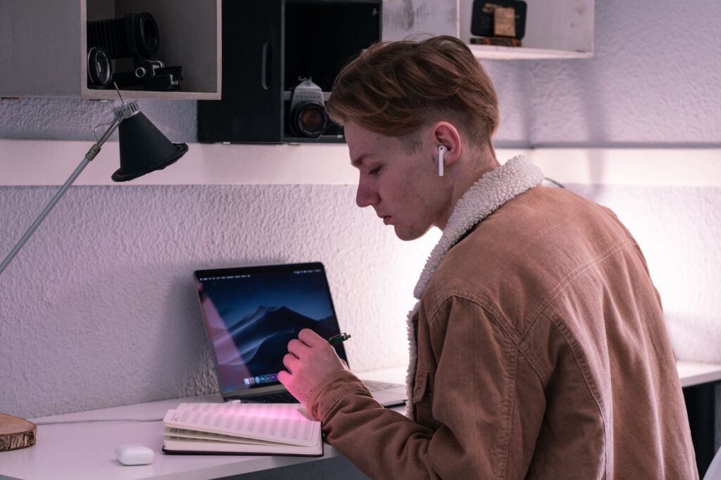 Student keeping on top of organisation with a paper planner at a desk with a laptop